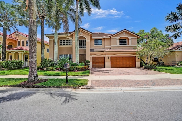 2509 Hunters Run Way, Weston, FL 33327 - mediterranean / spanish home featuring stucco siding, an attached garage, decorative driveway, and a front lawn