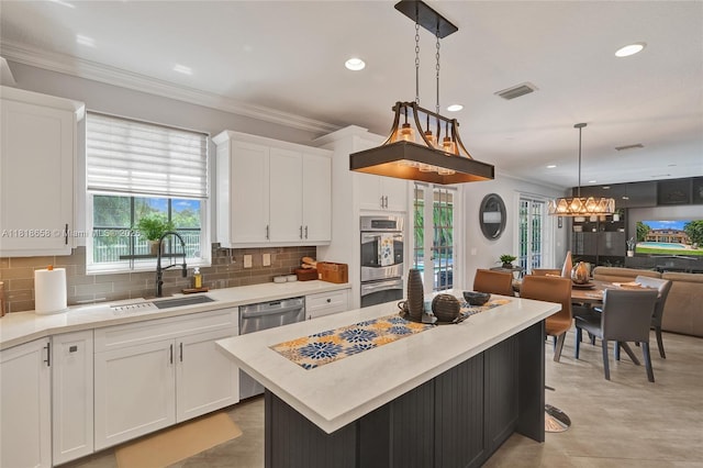 2509 Hunters Run Way, Weston, FL 33327 - kitchen with appliances with stainless steel finishes, white cabinets, decorative backsplash, a chandelier, and light countertops