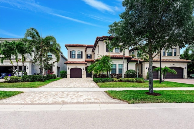 9368 Eden Roc Ct, Delray Beach, FL 33446 - mediterranean / spanish-style home featuring a garage, decorative driveway, a tiled roof, stucco siding, and a front lawn