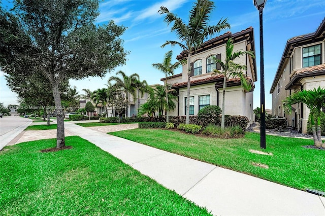 9368 Eden Roc Ct, Delray Beach, FL 33446 - view of front of house with stucco siding, a front yard, and a tile roof