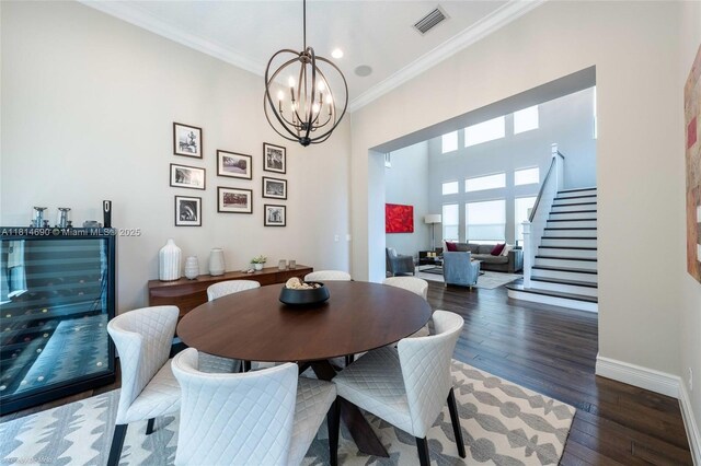 9368 Eden Roc Ct, Delray Beach, FL 33446 - dining space featuring crown molding, a chandelier, stairs, baseboards, and wood finished floors