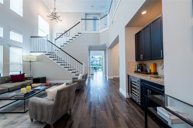 9368 Eden Roc Ct, Delray Beach, FL 33446 - living area featuring wine cooler, stairs, dark wood finished floors, bar, and baseboards