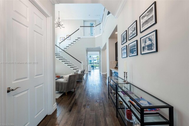 9368 Eden Roc Ct, Delray Beach, FL 33446 - hallway featuring stairway, dark wood-type flooring, a chandelier, and a towering ceiling