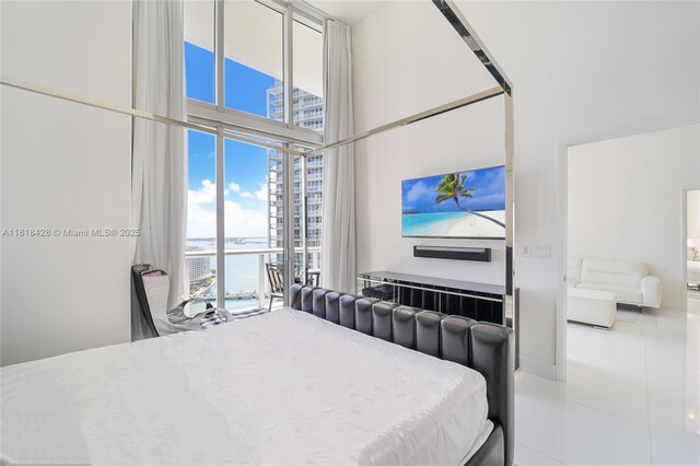 475 Brickell Ave Unit 2807, Miami, FL 33131 - tiled bedroom featuring a high ceiling, multiple windows, and a wall of windows