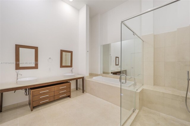 475 Brickell Ave Unit 2807, Miami, FL 33131 - full bathroom featuring a garden tub, tile patterned flooring, a shower stall, double vanity, and a high ceiling