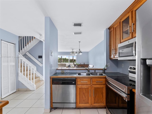 17337 SW 140th Ct, Miami, FL 33177 - kitchen featuring appliances with stainless steel finishes, a sink, brown cabinets, and dark countertops