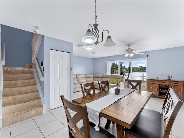 17337 SW 140th Ct, Miami, FL 33177 - dining space with stairway, light tile patterned floors, a ceiling fan, a chandelier, and a water view