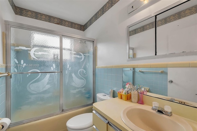 1150 W 69th Pl, Hialeah, FL 33014 - bathroom with toilet, tile walls, vanity, bath / shower combo with glass door, and a wainscoted wall