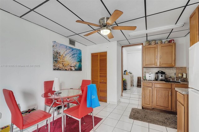 1150 W 69th Pl, Hialeah, FL 33014 - kitchen featuring ceiling fan, light tile patterned flooring, decorative backsplash, a sink, and freestanding refrigerator