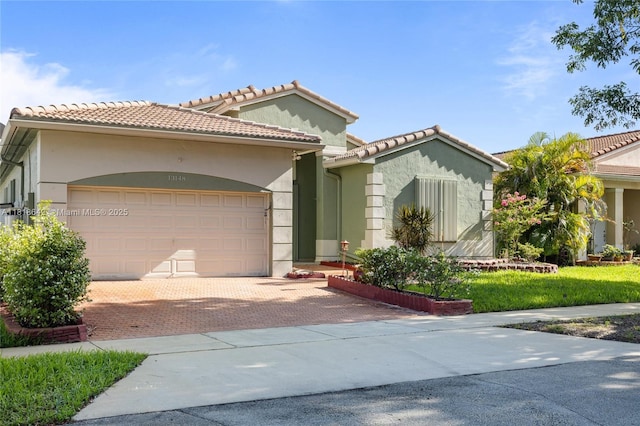 13148 SW 23rd St, Miramar, FL 33027 - mediterranean / spanish-style home with an attached garage, stucco siding, decorative driveway, and a tile roof