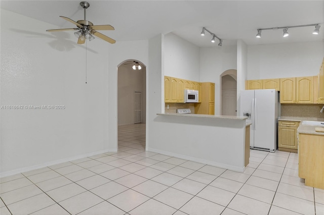 13148 SW 23rd St, Miramar, FL 33027 - kitchen with white appliances, arched walkways, light brown cabinets, a ceiling fan, and a towering ceiling