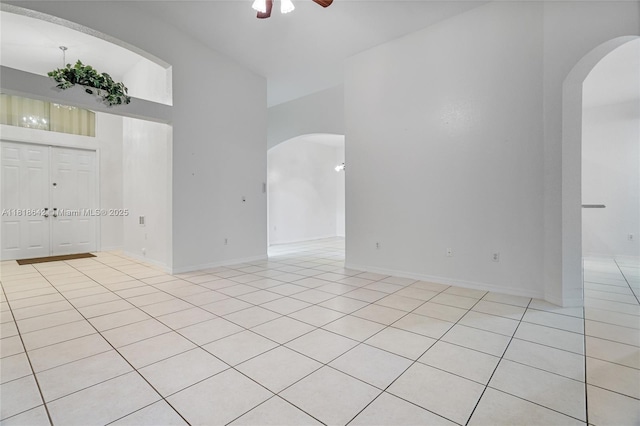 13148 SW 23rd St, Miramar, FL 33027 - spare room featuring arched walkways, a ceiling fan, light tile patterned floors, and a high ceiling