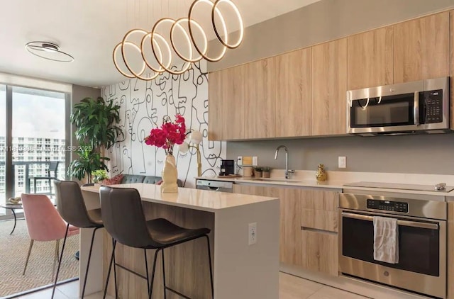3900 Biscayne Blvd Unit N-1011, Miami, FL 33137 - kitchen featuring stainless steel appliances, modern cabinets, light brown cabinets, a sink, and expansive windows