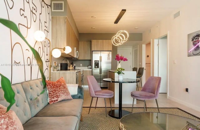 3900 Biscayne Blvd Unit N-1011, Miami, FL 33137 - kitchen featuring stainless steel fridge with ice dispenser, light brown cabinetry, decorative light fixtures, light countertops, and baseboards