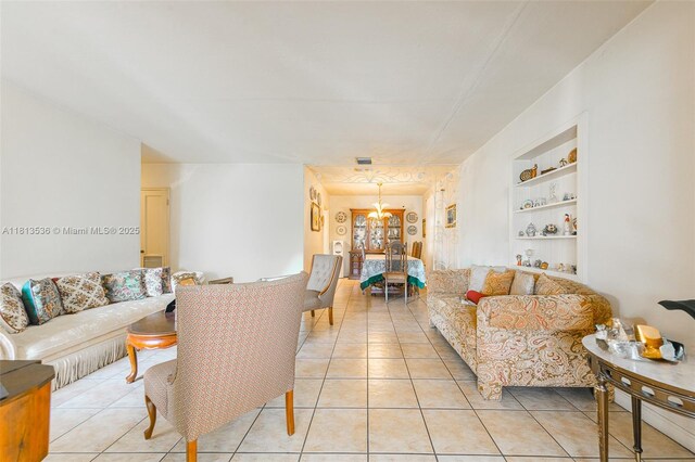 7280 SW 9th St, Miami, FL 33144 - living room with built in shelves, light tile patterned floors, and a chandelier
