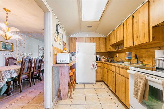 7280 SW 9th St, Miami, FL 33144 - kitchen featuring white appliances, a chandelier, vaulted ceiling, light tile patterned floors, and light countertops