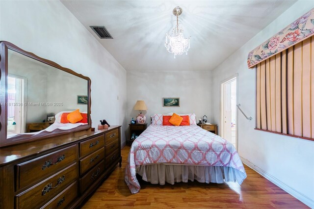 7280 SW 9th St, Miami, FL 33144 - bedroom with a chandelier, wood finished floors, and multiple windows