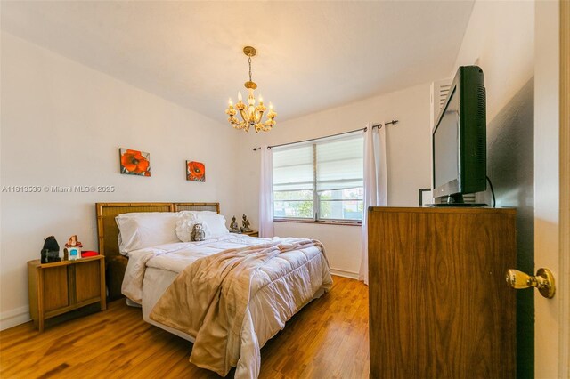7280 SW 9th St, Miami, FL 33144 - bedroom with a chandelier, wood finished floors, and baseboards