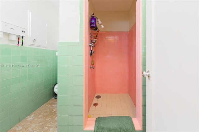 7280 SW 9th St, Miami, FL 33144 - bathroom featuring a stall shower, toilet, tile walls, tile patterned floors, and wainscoting