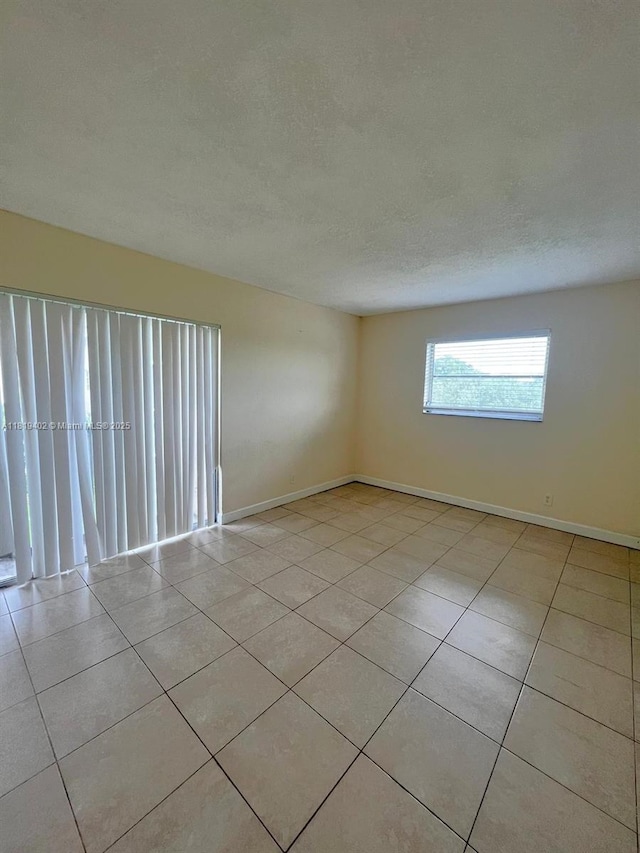 8740 N Sherman Cir Unit 308, Miramar, FL 33025 - spare room with light tile patterned flooring and a textured ceiling