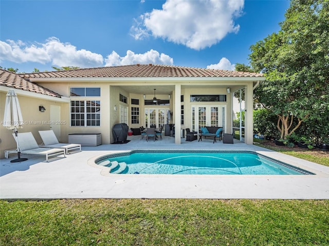 643 Lake Blvd, Weston, FL 33326 - rear view of property featuring an outdoor hangout area, an outdoor pool, a patio, and a tiled roof