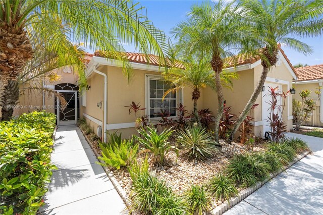 7182 Burgess Dr, Lake Worth, FL 33467 - mediterranean / spanish house with a garage, stucco siding, a tile roof, and driveway