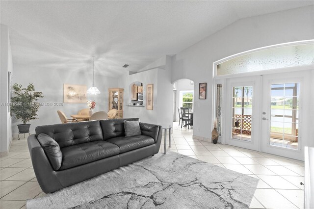 7182 Burgess Dr, Lake Worth, FL 33467 - tiled living area with french doors, lofted ceiling, and arched walkways