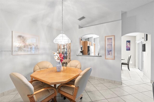 7182 Burgess Dr, Lake Worth, FL 33467 - dining room with arched walkways, light tile patterned floors, vaulted ceiling, and baseboards
