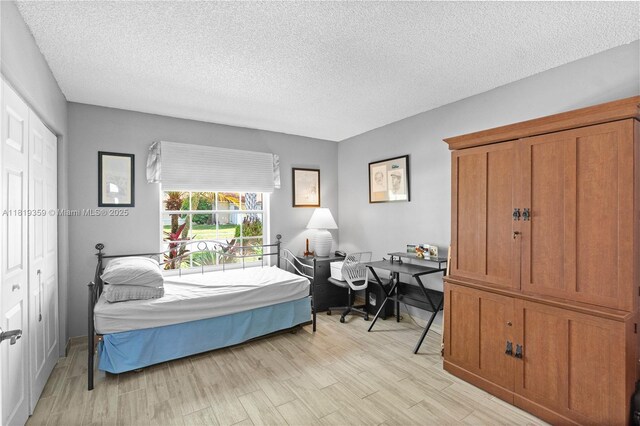 7182 Burgess Dr, Lake Worth, FL 33467 - bedroom with a textured ceiling and light wood-style floors