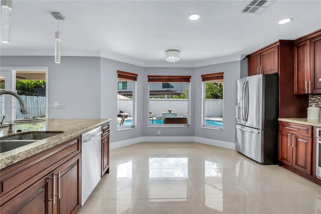 2635 SW 183rd Ave, Miramar, FL 33029 - kitchen with appliances with stainless steel finishes, recessed lighting, light stone counters, decorative light fixtures, and backsplash