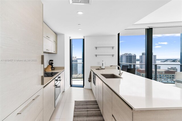 1300 S Miami Ave Unit 2305, Miami, FL 33130 - kitchen with a sink, floor to ceiling windows, modern cabinets, a peninsula, and stainless steel oven
