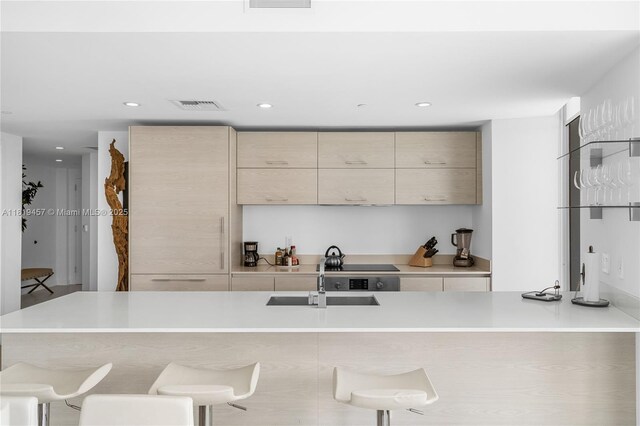 1300 S Miami Ave Unit 2305, Miami, FL 33130 - kitchen with modern cabinets, a sink, a breakfast bar area, light countertops, and recessed lighting
