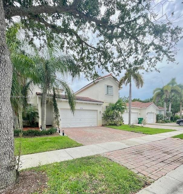 18796 SW 27th Ct, Miramar, FL 33029 - mediterranean / spanish home with decorative driveway, stucco siding, a tiled roof, a garage, and a front lawn