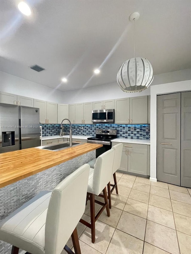 18796 SW 27th Ct, Miramar, FL 33029 - kitchen with appliances with stainless steel finishes, a sink, backsplash, light tile patterned floors, and decorative light fixtures