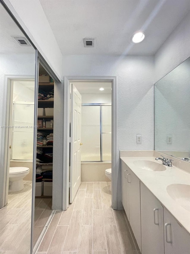 18796 SW 27th Ct, Miramar, FL 33029 - full bath with toilet, wood finished floors, double vanity, and bath / shower combo with glass door