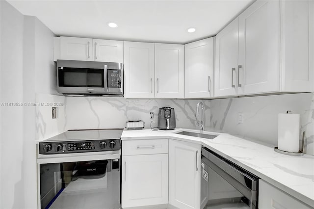 3015 N Ocean Blvd Unit 4K, Fort Lauderdale, FL 33308 - kitchen with stainless steel microwave, electric stove, a sink, white cabinetry, and recessed lighting