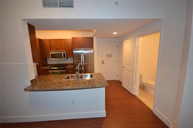 400 N Federal Hwy Unit 302S, Boynton Beach, FL 33435 - kitchen featuring appliances with stainless steel finishes, a sink, a peninsula, dark wood finished floors, and dark stone counters
