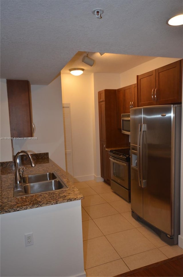 400 N Federal Hwy Unit 302S, Boynton Beach, FL 33435 - kitchen with appliances with stainless steel finishes, a sink, a peninsula, light tile patterned floors, and dark stone countertops