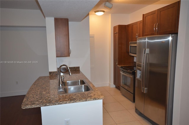 400 N Federal Hwy Unit 302S, Boynton Beach, FL 33435 - kitchen with stainless steel appliances, a peninsula, a sink, baseboards, and light tile patterned flooring
