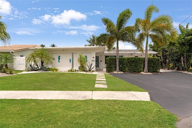 806 Argonaut Is, Dania Beach, FL 33004 - view of front of home with stucco siding, a front lawn, and asphalt driveway