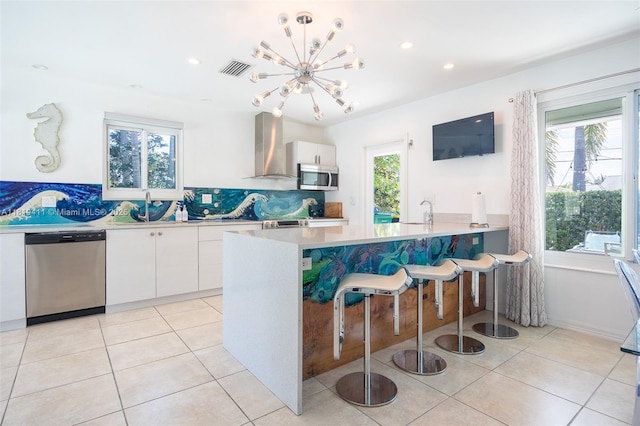 806 Argonaut Is, Dania Beach, FL 33004 - kitchen with stainless steel appliances, white cabinets, wall chimney range hood, healthy amount of natural light, and recessed lighting