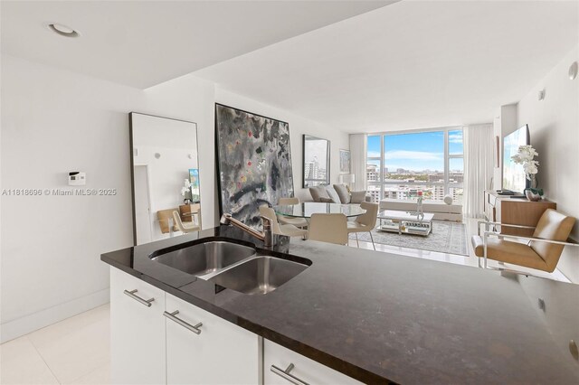 6801 Collins Ave Unit 1401, Door Number Miami Beach, FL 33141 - kitchen with a sink, floor to ceiling windows, white cabinets, light tile patterned floors, and open floor plan