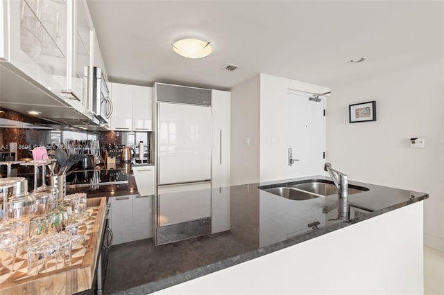 6801 Collins Ave Unit 1401, Door Number Miami Beach, FL 33141 - kitchen featuring a sink, built in refrigerator, dark stone countertops, and white cabinets