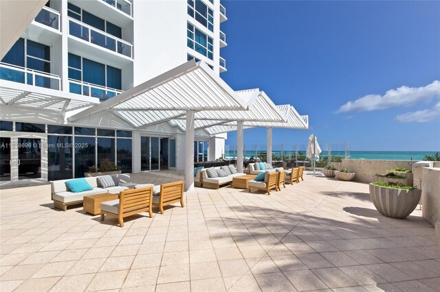 6801 Collins Ave Unit 1401, Door Number Miami Beach, FL 33141 - view of patio / terrace with outdoor lounge area, a pergola, and a water view