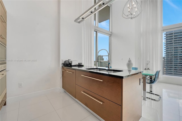 485 Brickell Ave Unit 4004, Miami, FL 33131 - kitchen featuring modern cabinets, a chandelier, light tile patterned floors, decorative light fixtures, and dark countertops
