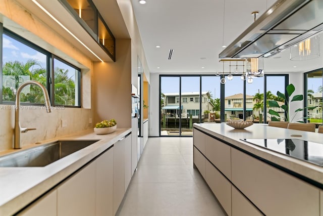 2033 NE 22nd St, Wilton Manors, FL 33305 - kitchen with a sink, light countertops, modern cabinets, black electric cooktop, and white cabinets