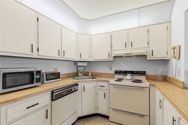 311 Pine Ridge Cir Unit C-2, Green Acres, FL 33463 - kitchen with white appliances, under cabinet range hood, a sink, light countertops, and a textured ceiling