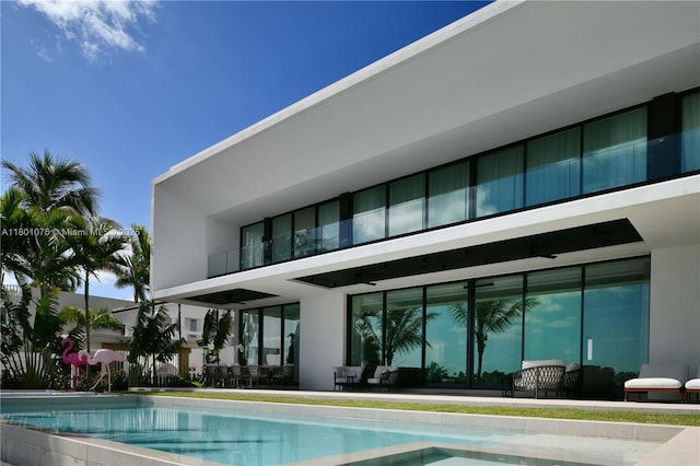 375 N Hibiscus Dr, Miami Beach, FL 33139 - rear view of property with a balcony, stucco siding, and an outdoor pool