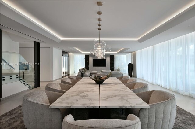 375 N Hibiscus Dr, Miami Beach, FL 33139 - dining area featuring a tray ceiling, a chandelier, and tile patterned flooring