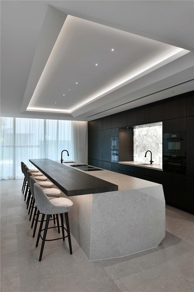 375 N Hibiscus Dr, Miami Beach, FL 33139 - kitchen with a raised ceiling, modern cabinets, black oven, and built in microwave